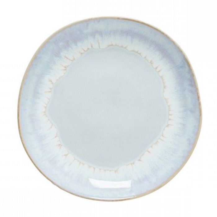 The Brisa Sal Dinnerware by Casafina/Costa Nova is a round, light blue stoneware plate with a subtle gradient pattern, slightly uneven rim, and glossy finish, inspired by the Algarve coast’s natural tones.
