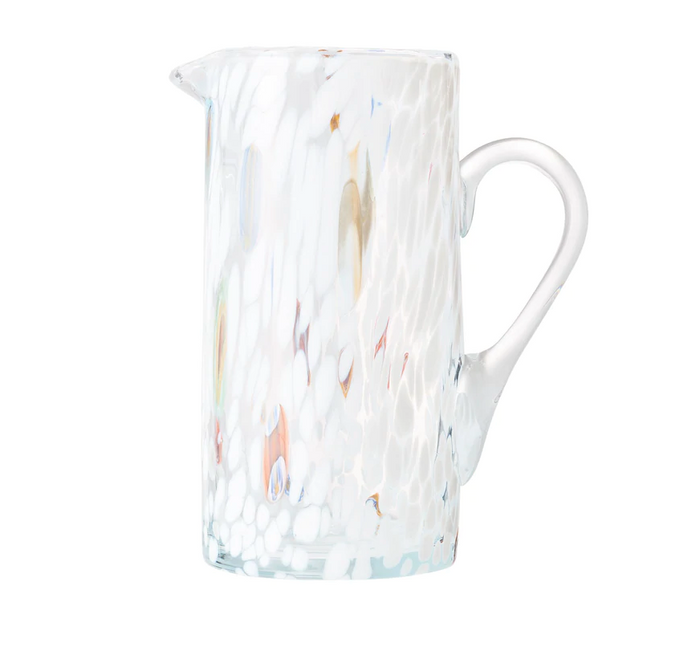 The Kim Seybert Gala Pitcher White is a tall, clear pitcher with a side handle, featuring a white, textured speckled pattern and subtle color accents that highlight the elegance of Murano-style glass.