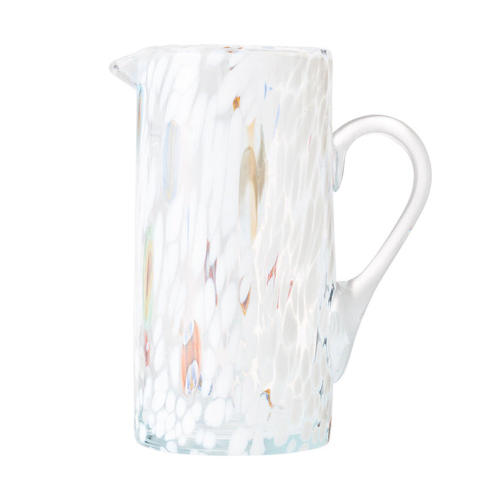 The Kim Seybert Gala Pitcher White is a glass pitcher with a handle, featuring a white textured pattern, subtle multicolored spots, and a glossy, slightly translucent finish.