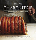 Open charcuterie cookbook by Penguin Random House LLC featuring cheese, meats, and appetizer preparations on a rustic wooden table.