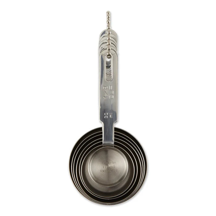 Set of seven RSVP International measuring cups and spoons with bowls, made of stainless steel, arranged in a stack on a white background.