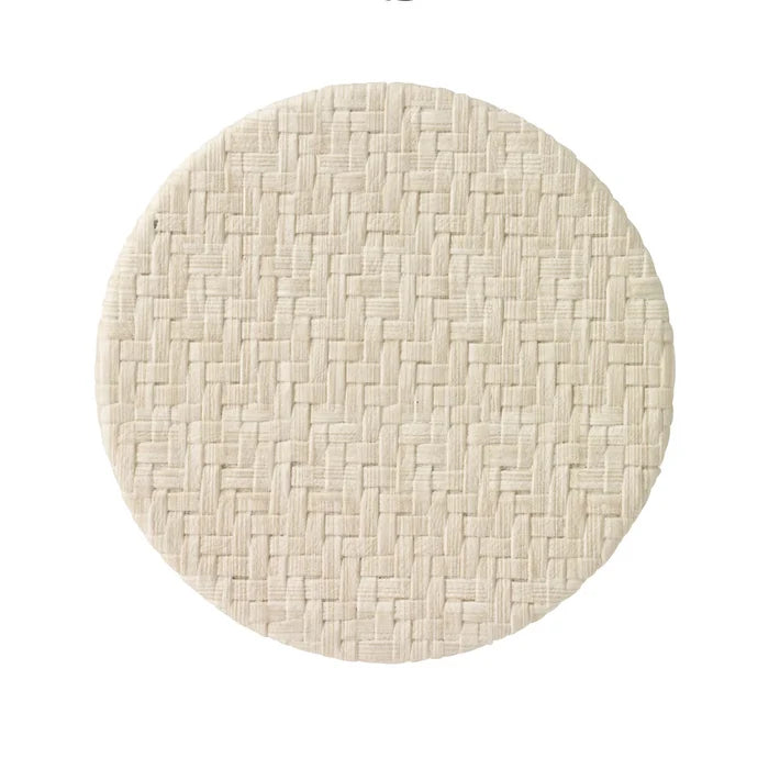 The Bodrum Wicker Easy Care Coaster Set features round, beige coasters with a subtle basketweave design and felt backing, displayed on a white background.